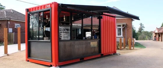 Retail Ready: Container Kiosks for Quick Service and Food Vending Modern red shipping container retail kiosk with a large service window and awning, designed for use as a cafe or food vendor.