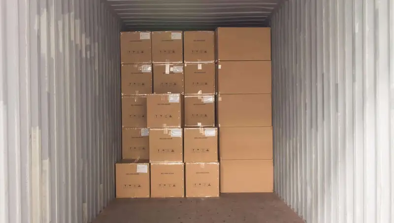 Full Capacity: Maximizing Space Inside Your Storage Container Interior view of a shipping container packed nearly full with neatly stacked cardboard boxes and cartons for storage.