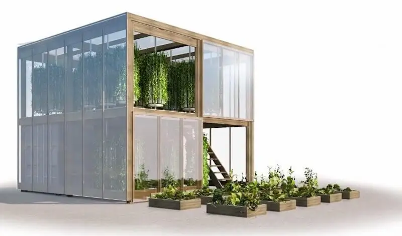greenhouse-article-premium-two-story-vertical-farm Two-story modular greenhouse built from glass and wood, with lush vertical farming vines growing inside.