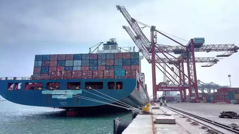 The SSL Brahmaputra container ship docked at a Nhava Sheva berth under red cranes.