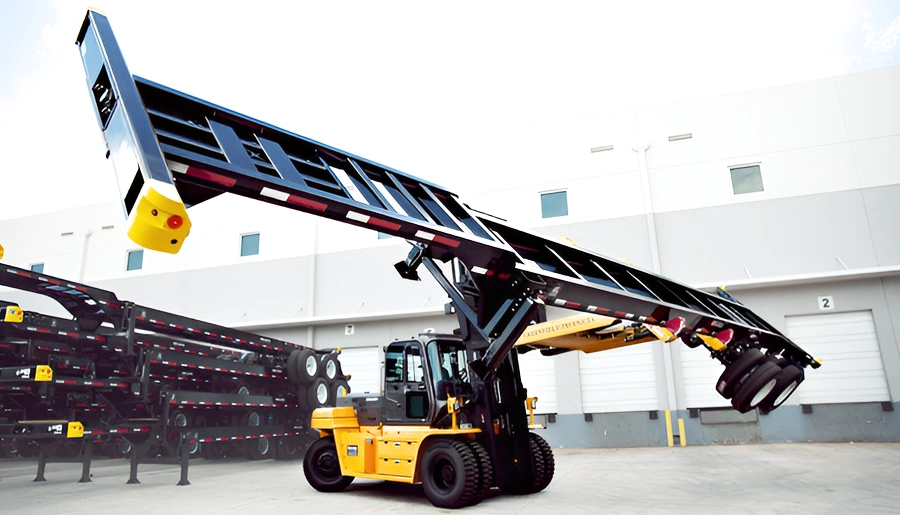 A heavy-duty forklift lifting a large container chassis