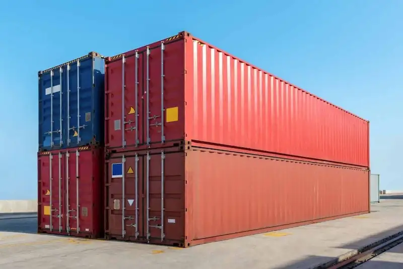 Dos grandes contenedores rojos de 40 pies apilados con una unidad azul, destacando su popular tamaño para almacenamiento y transporte.