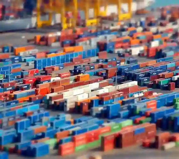 Tilt-shift photo of a large cargo port showing hundreds of multi-colored containers like miniature models, symbolizing inventory.
