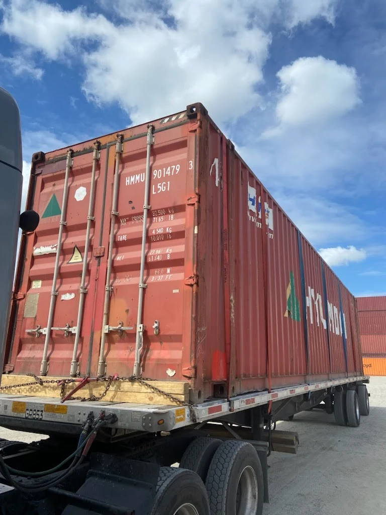 Rear view of a 45ft high cube shipping container mounted on a chassis trailer in a logistics yard