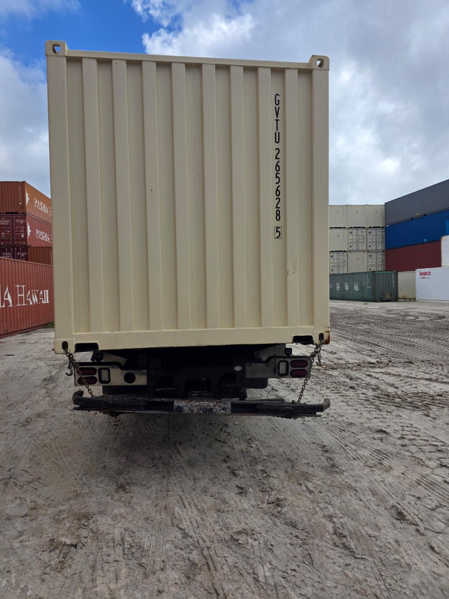 Rear view of 20ft one trip container on chassis truck parked on dirt surface