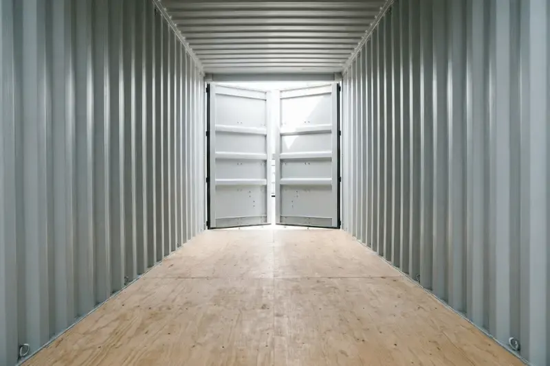 Interior de un limpio contenedor de transporte de un solo viaje, con impecables suelos de madera contrachapada y paredes de acero gris claro.