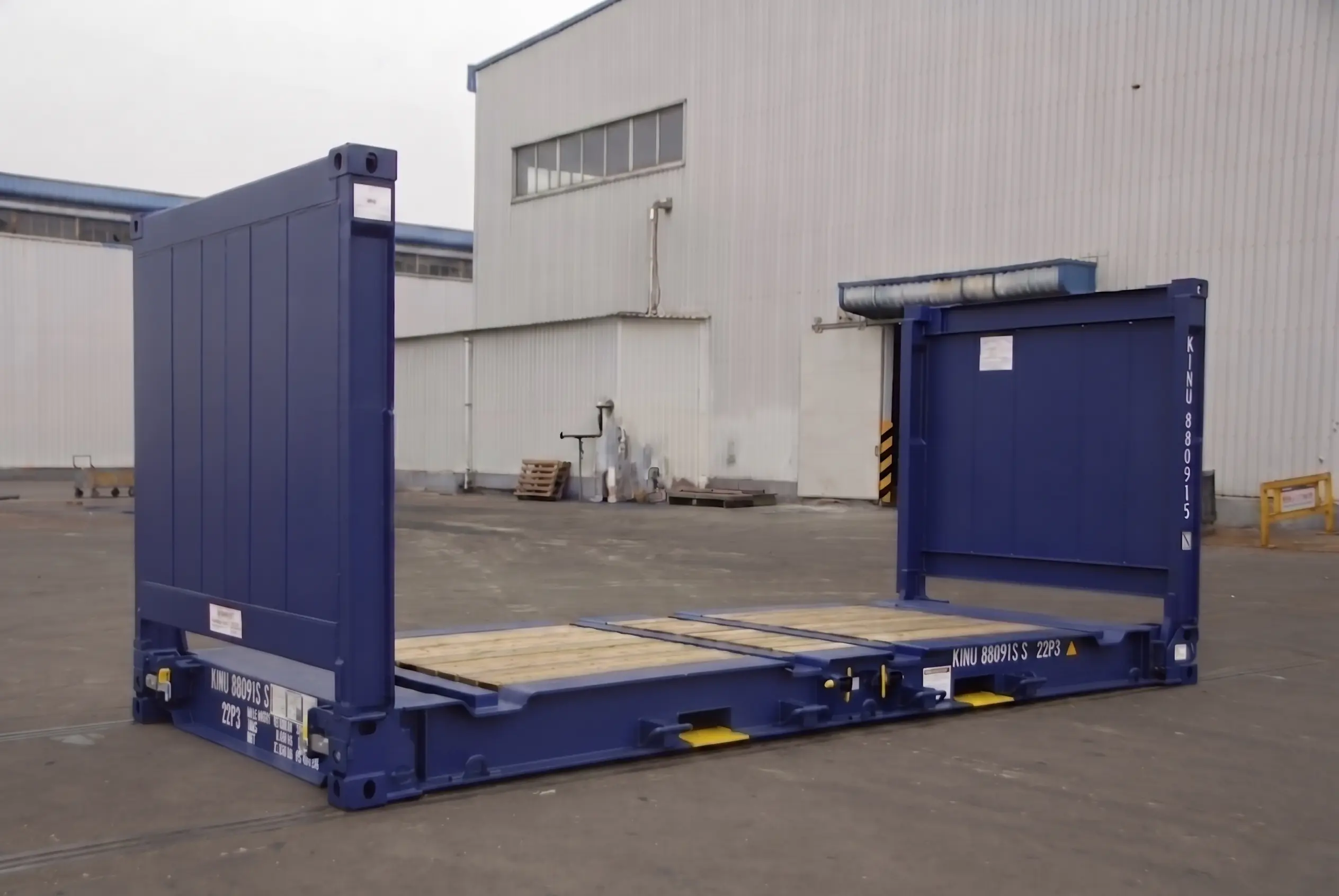 A blue 20ft flat rack container with end walls upright and a reinforced timber floor.