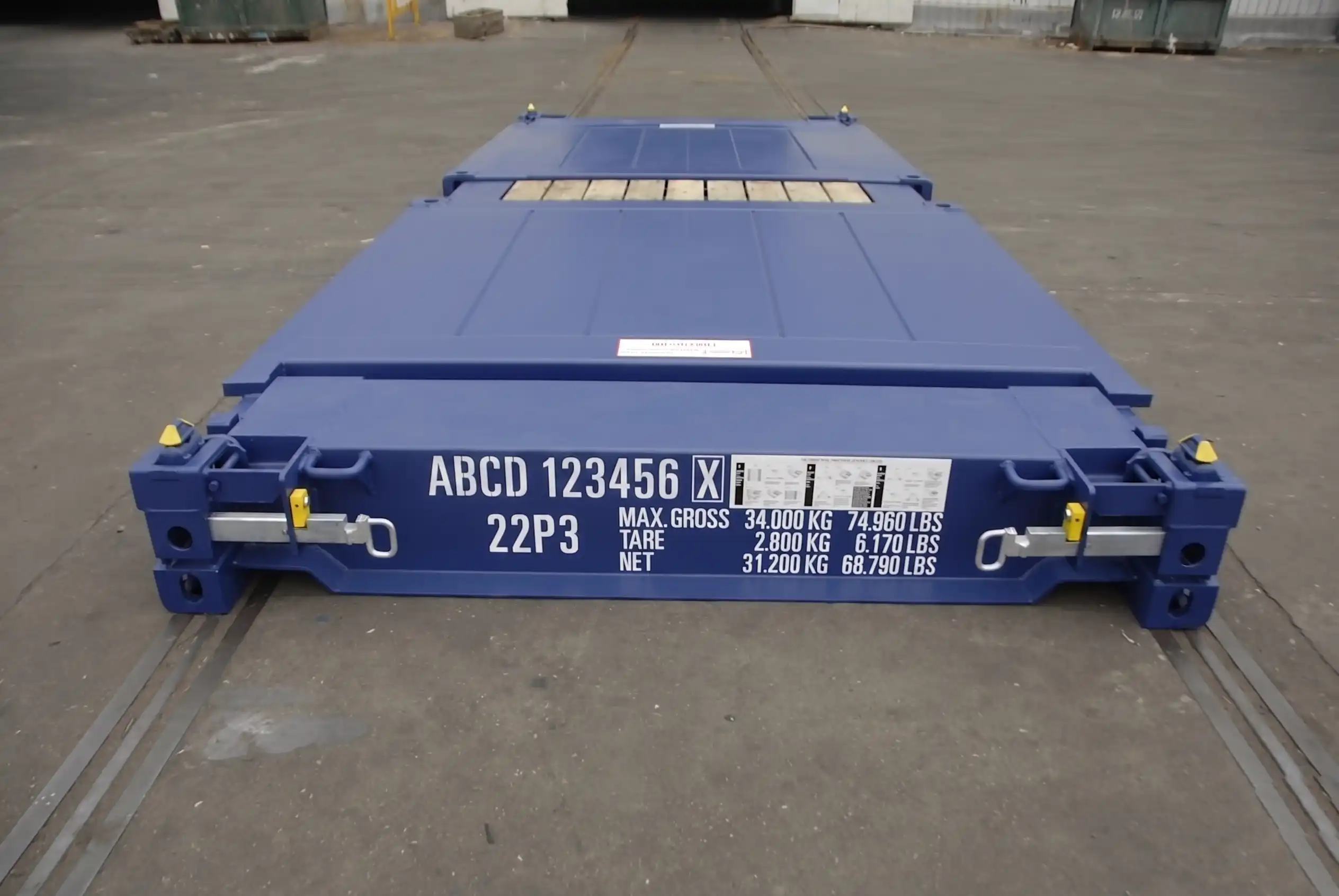 Close up of a blue 20ft flat rack container showing ISO weight markings and collapsible locking pins
