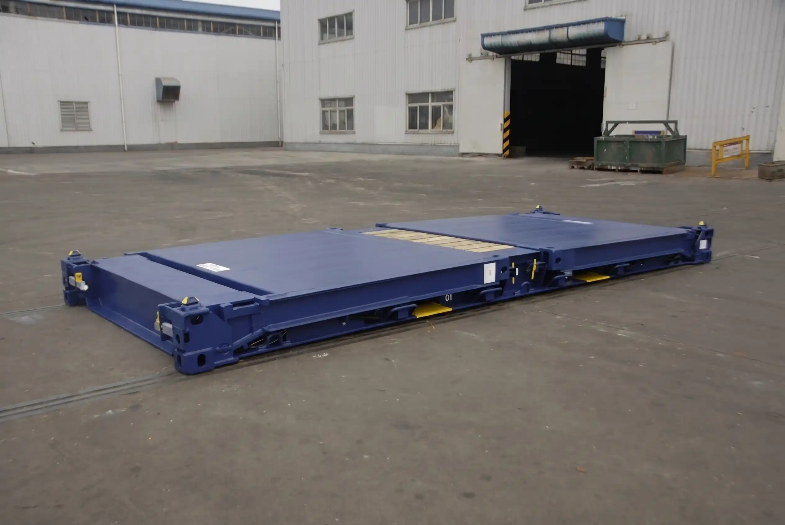 Side view of a blue 20ft flat rack container with end walls folded down flat for easy stacking.