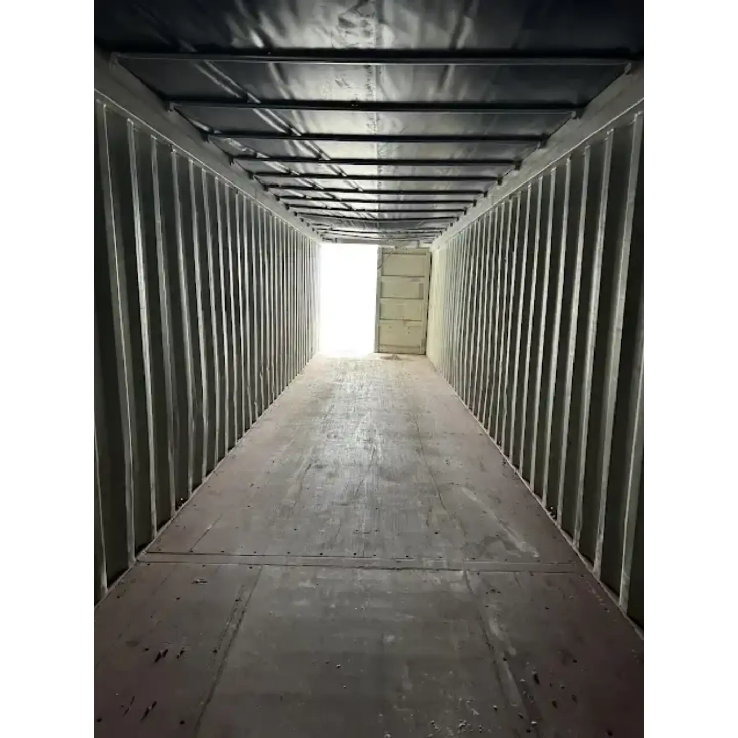 Inside view of an empty 40ft open top container showing the steel walls, timber floor, and roof bows.